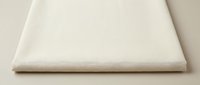 Beige cream colored fabric textile material with soft texture and natural fibers, folded edge detail on neutral background for sewing crafts.