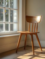 Empty wooden chair near bright window with natural sunlight casting shadows on hardwood floor, minimalist interior design composition for home decor and furniture.