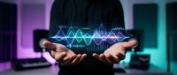 Young male professional displaying holographic sound wave visualization between hands in modern tech environment with neon lighting.