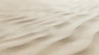 Fine golden sand dunes with natural wind-carved ripples and soft shadows creating textured desert landscape background for travel and nature designs.