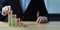 Businessman arranging wooden blocks spelling COST with downward arrows showing expense reduction and budget optimization strategies for financial management.