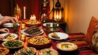 Traditional Middle Eastern feast with grilled kebabs, rice dishes, and mezze spread on ornate table with lanterns and warm candlelight creating authentic dining atmosphere.