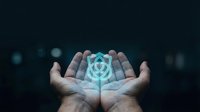 Hands holding glowing digital shield with target symbol, representing cybersecurity protection, data safety, and network defense for technology and business concepts.