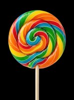 Colorful spiral lollipop with red, orange, yellow, green, and blue swirls on wooden stick, isolated on transparent background. Ready for clipart, t-shirt designs, stickers, and print-on-demand products.