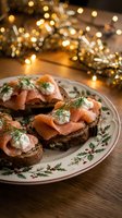 Smoked salmon canapes with cream cheese and dill on dark bread served on festive plate with warm bokeh lights creating cozy holiday atmosphere.