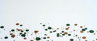 Scattered colorful confetti dots in green, brown and black tones on white background for party decorations and festive celebrations.