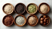 Assortment of healthy seeds, nuts and grains in wooden bowls on light background. Nutritious ingredients for cooking and baking.