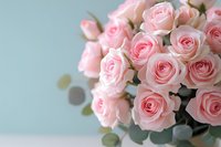 Elegant bouquet of soft pink roses against pastel blue background, perfect for wedding invitations, greeting cards, and romantic designs.