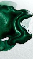 Abstract emerald green fluid paint splash with organic flowing shapes on white background for creative design projects and artistic compositions.