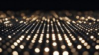 Abstract golden light dots pattern creating depth perspective on dark background for modern digital design projects.
