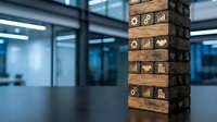 Wooden blocks stacked vertically with business icons representing finance, growth, and strategy in modern office environment with blurred background.