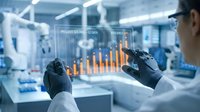 Engineer in white protective suit and gloves analyzing holographic data visualization with orange bar charts in modern laboratory environment for industrial analysis and technology research.