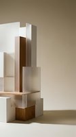 Abstract geometric composition with white and wooden blocks arranged in architectural formation on neutral beige background for modern design projects.