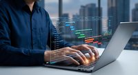 Professional businessman analyzing financial data and market trends on laptop with holographic charts and graphs overlay in modern office environment.