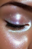 Closed eye with iridescent glitter makeup, featuring holographic shimmer and sparkles on medium skin tone. Professional beauty cosmetics application for editorial styling.
