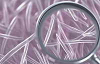 Magnifying glass revealing detailed crystal structure in pink and white tones, macro photography showing scientific research and molecular patterns.