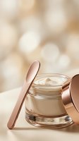 Luxury skincare cream jar with rose gold spatula and lid on elegant bokeh background for premium beauty and cosmetic product advertising.