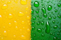 Water drops on dual colored yellow and green surface creating abstract pattern with light reflection and condensation effect for fresh beverage background.