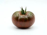 Fresh dark red heirloom tomato with green stem isolated on white background, suitable for food, cooking, and culinary design projects.