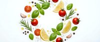 Fresh ingredients arranged in circular pattern with tomatoes basil leaves lemon slices garlic and herbs on white background for culinary design.