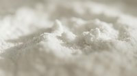 White powder substance with fine granular texture, close-up macro shot showing crystalline particles and light reflections for culinary, chemical, or industrial applications.