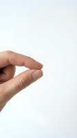 Close-up of a hand with fingers pinched together in a small gesture against a white background, suitable for business, communication, and instructional design projects.