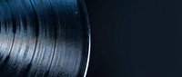 Close-up of vinyl record with detailed grooves and reflective surface on dark background for music and audio production projects.