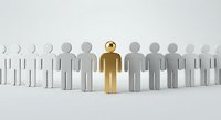 Golden figure standing out among white paper cutout people in row representing leadership and uniqueness in business team.