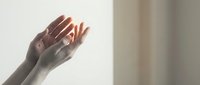 Gentle female hands cupped together in soft natural light creating peaceful meditation pose for wellness and mindfulness concepts.