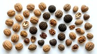 Whole and cracked walnuts arranged on white background, overhead view. Suitable for food photography, nutrition content, recipe blogs, healthy eating campaigns, and culinary design projects.