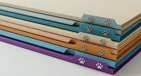 Colorful pet care books stacked with paw print embossing on spines, featuring teal, orange, and purple covers for animal lovers and veterinary education.