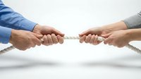 Business tug of war concept with two people pulling rope in opposite directions representing competition, conflict resolution and teamwork challenges.