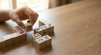 Hand arranging wooden blocks with social media icons on desk representing digital marketing strategy and brand building for business growth.