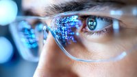 Close up view of eye wearing smart augmented reality glasses with glowing blue digital data and information display, representing future technology and innovation.