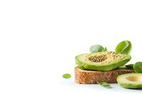 Avocado slices and seeds on whole grain toast isolated on white background, ready for healthy breakfast, nutrition, and food design projects.