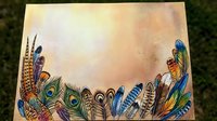 Colorful feathers border frame with peacock plumes and exotic bird feathers on textured background for bohemian design projects and natural decorative elements.