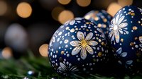 Navy blue Christmas ornaments with white and gold floral pattern against blurred bokeh lights background, creating festive holiday atmosphere. Decorative seasonal arrangement.