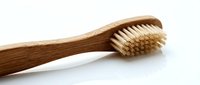 Eco-friendly bamboo toothbrush with natural bristles isolated on white background for sustainable oral hygiene and zero waste lifestyle products.