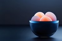 Fresh eggs in black ceramic bowl against dark background, soft natural lighting creates gentle shadows and highlights organic texture of eggshells.