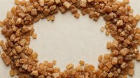 Caramel popcorn pieces arranged in a circular frame on neutral background, ideal for food packaging and snack marketing designs.