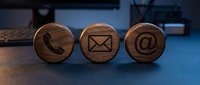 Wooden contact icons with phone, envelope, and email symbols on blue surface for business communication and customer service.