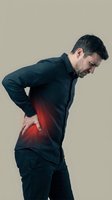 Adult Caucasian man holding his lower back with red pain highlight, suffering from acute backache on neutral background.