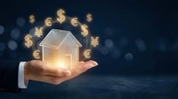 Businessman hand holding glowing house model with floating currency symbols representing real estate investment and property financing opportunities.