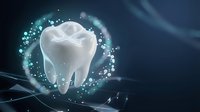 Glowing white tooth with sparkling particles and light effects on dark blue background for dental care and oral health concepts.