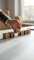 Businessman hand placing wooden cube with checkmark among row of blocks on office desk representing quality control and business decision making.