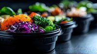 Fresh poke bowl with salmon roe, red cabbage, seaweed and vegetables in black takeout container on dark background, healthy Asian food concept.