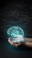 Glowing digital brain hologram floating above cupped hands against dark stone wall background for artificial intelligence and neuroscience concepts.