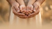 Four cupped hands forming protective gesture together, symbolizing teamwork, support, care and unity in warm golden light for wellness concepts.