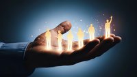 Businessman hand holding glowing human figures representing team leadership, talent management and human resources development in corporate environment.