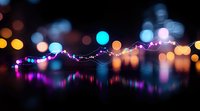 Colorful bokeh lights and string fairy lights reflecting on dark glossy surface creating dreamy nighttime atmosphere with vibrant purple and blue tones.
